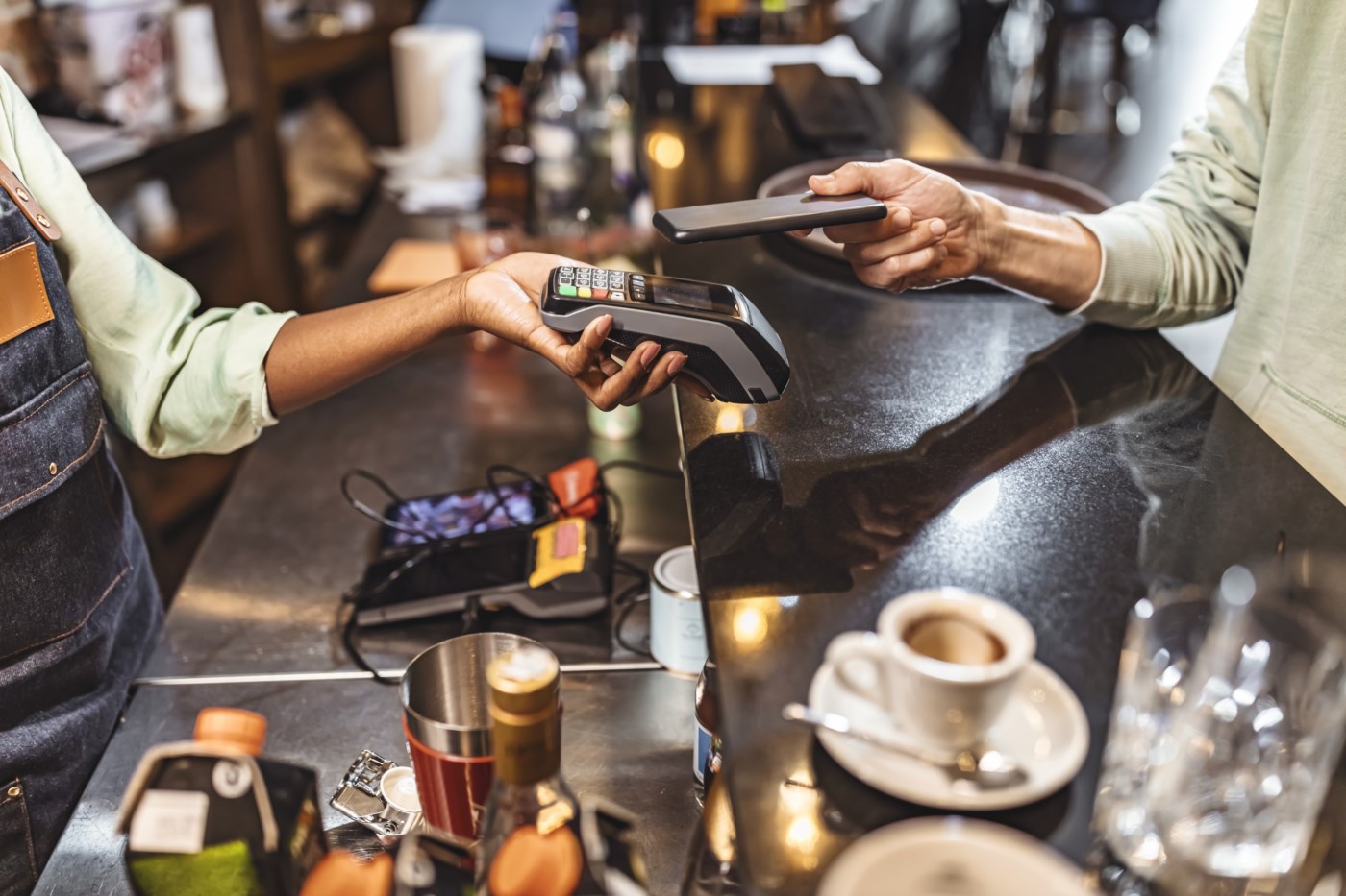 Kunde betaler med mobilen i kassa – kontaktløs mobilbetaling i butikk