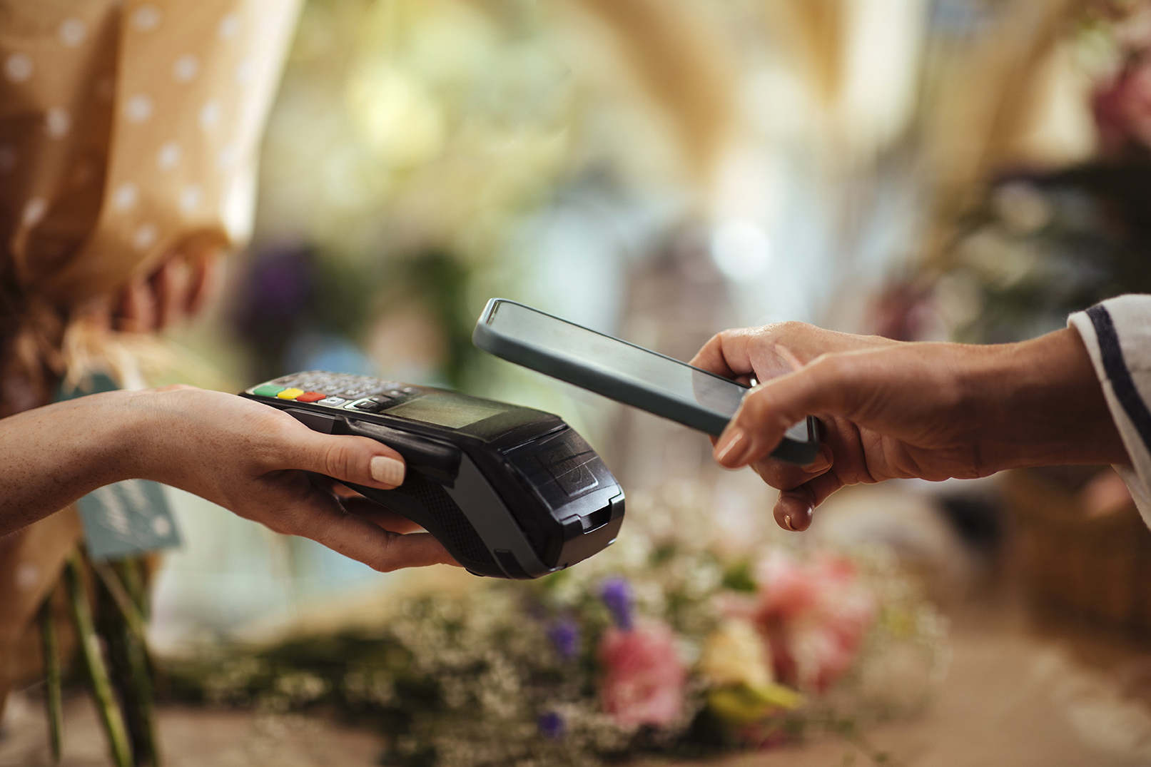 Person betaler kontaktløst med mobilen i butikk.