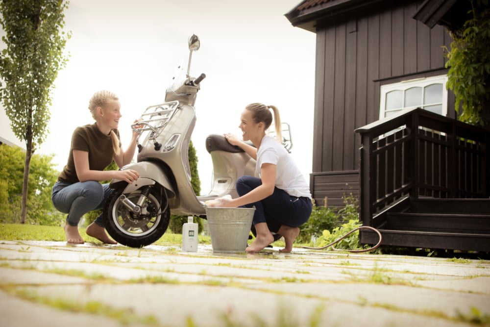 to jenter som vasker en scooter på gårdsplassen